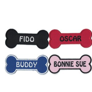 May include: Four dog bone-shaped patches with embroidered names. The patches are black, red, blue, and pink. The names are "Fido", "Oscar", "Buddy", and "Bonnie Sue".