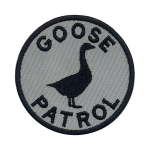 May include: A gray circular patch with black embroidered text that reads "GOOSE PATROL" and a black silhouette of a goose.