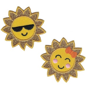 May include: Two embroidered iron-on patches featuring a yellow sun with a smiling face. One sun is wearing sunglasses and the other has a pink blush and a red bow.