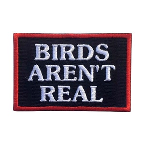 May include: A rectangular patch with the text "BIRDS AREN'T REAL" in white, embroidered on a black background. The patch has a red border. The patch is likely for clothing or accessories.