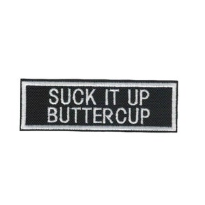 May include: Black and white embroidered patch with the text "SUCK IT UP BUTTERCUP" in white lettering.