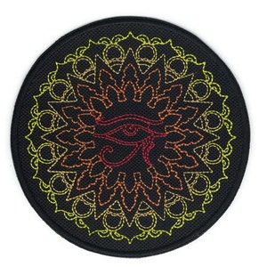 May include: A round black patch with an embroidered design of an eye with a mandala-like pattern in shades of yellow, orange, and red.