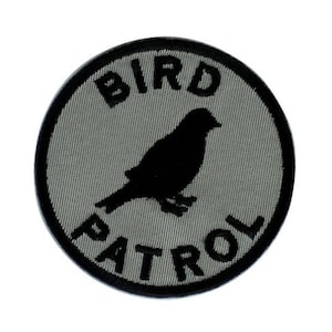 May include: A gray and black circular patch with the text "BIRD PATROL" and a silhouette of a bird.