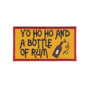 May include: A yellow embroidered patch with red stitching. The patch reads "Yo ho ho and a bottle of rum" with a cartoon bottle of rum and a swirl.
