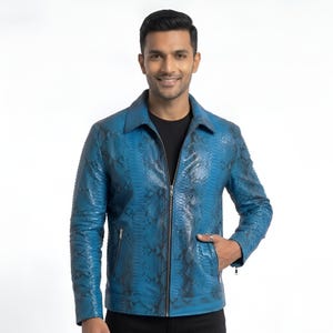 Pode incluir: Uma jaqueta azul vibrante com um padrão detalhado de pele de cobra em preto. Esta peça de manga comprida inclui uma gola clássica, um fecho de correr frontal completo e dois bolsos laterais com fechos de correr em tom prateado.