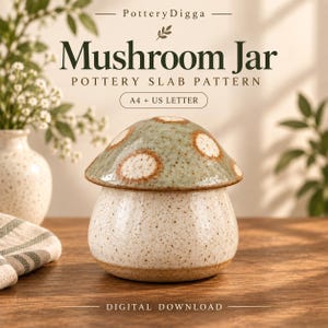 Op de afbeelding: Een paddenstoelvormige keramische pot met een gespikkelde crèmekleurige basis en een saliegroene hoed met witte stippen. De tekst PotteryDigga Mushroom Jar Pottery Slab Pattern A4 + US Letter Digital Download is zichtbaar op de achtergrond.