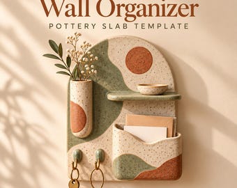 May include: A speckled ceramic wall organizer with the text PotteryDigga Wall Organizer Pottery Slab Template. It features a cylindrical vase, a small shelf with a bowl, a pocket for mail, and two hooks holding metal key rings.