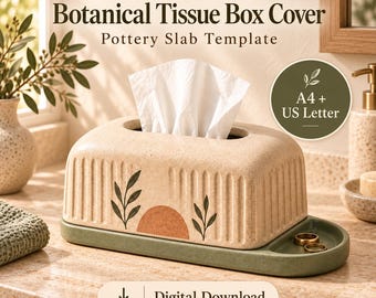 May include: A beige rectangular tissue box cover with vertical ribbed sides and a botanical design featuring green leaves and a terracotta semi-circle. The cover sits on a green tray with a small circular indentation. Text reads PotteryDigga.