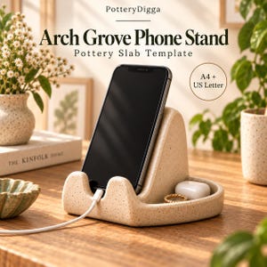 Peut inclure: Un support de téléphone en céramique beige moucheté avec un dos arqué, tenant un smartphone noir relié à un câble de charge blanc. La base comporte un petit plateau contenant un boîtier d'écouteurs blanc et une bague dorée. Texte : Arch Grove Phone Stand.
