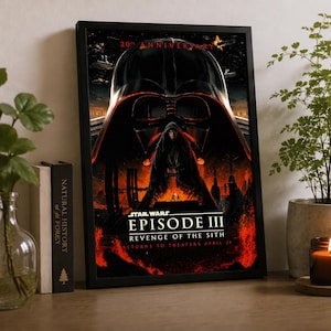 Könnte beinhalten: Ein gerahmtes Star Wars Episode III Die Rache der Sith 20-Jahre-Jubiläums-Filmplakat mit der Silhouette eines Darth-Vader-Helms, einer Kapuzenfigur und einer Lichtschwert-Duellszene in feurigen Rot- und Schwarztönen mit Text.