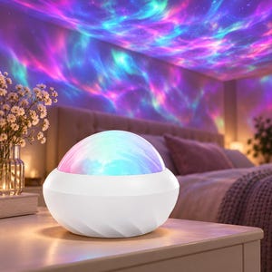 Könnte beinhalten: Ein weißer, kuppelförmiger Lichtprojektor mit einer glatten, abgerundeten Basis. Das Gerät strahlt eine lebendige, mehrfarbige Projektion aus wirbelnden blauen, violetten und rosafarbenen nebelartigen Mustern aus, die Wände und Decke beleuchten.