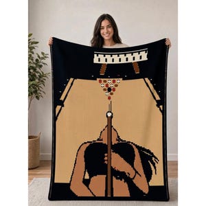 May include: A rectangular throw blanket featuring a pixel art design of a bowling alley. The black background frames a tan lane with a set of ten pins at the far end. A figure in a black top stands in the foreground holding a brown bowling ball.