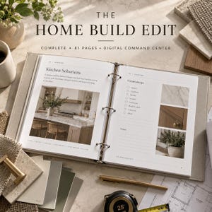 May include: An open three-ring binder titled The Home Build Edit, featuring 81 pages and a digital command centre. The pages display kitchen selections, countertop checklists, and interior photos. A gold pen and a 25-foot measuring tape are nearby.