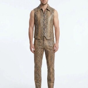 May include: A sleeveless vest and matching trousers set featuring a brown and tan snakeskin pattern. The vest has a pointed collar and a full-length vertical silver zipper closure down the center. The trousers are fitted with a standard waistband.