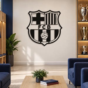 May include: A black metal wall art piece featuring the FC Barcelona crest, including the St. George's Cross, the Catalan flag stripes, the letters FCB, and a football graphic, mounted on a plain wall in a room with blue furniture.