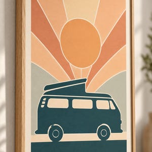 May include: A framed wall art print featuring a dark teal camper van silhouette positioned against a background of a large orange sun and radiating light beams in shades of peach, cream, and muted green, all enclosed in a light wood frame.