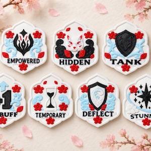 May include: Seven white hexagonal tokens featuring red cherry blossoms, light blue swirling clouds, and black icons with text. The tokens are labelled EMPOWERED, HIDDEN, TANK, +1 BUFF, TEMPORARY, DEFLECT, and STUNNED, each with unique central graphic symbols.