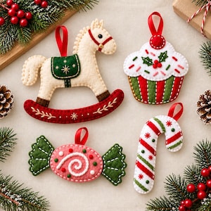 Puede incluir: Cuatro adornos navideños de fieltro que incluyen un caballo balancín color crema con silla verde, un cupcake blanco con rayas rojas y verdes, un caramelo rosa con envoltorios verdes y un bastón de caramelo blanco con rayas diagonales.