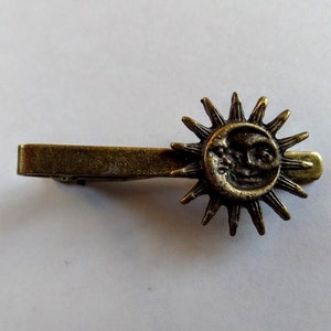 Pasador de corbata antiguo de bronce con forma de sol y luna