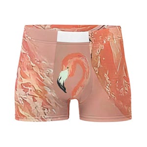 May include: Boxer briefs featuring a pink and peach abstract pattern with a central graphic of a flamingo head. The flamingo has a light-colored beak with a black tip and a white band at the top of the waistband. The fabric displays a textured, painterly aesthetic across the entire garment surface.