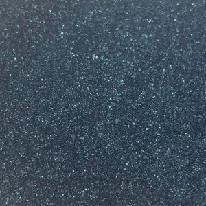 May include: A dark teal surface with a dense, fine-grained glitter texture. The material features a consistent, reflective finish that catches light across the entire surface, creating a shimmering effect with deep blue and green tones throughout.