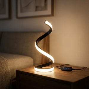 Op de afbeelding: Een spiraalvormige LED-tafellamp met een zwarte buitenkant en een doorlopende witte lichtstrip langs de binnenbocht. De lamp heeft een zwart netsnoer met een geïntegreerde schakelaar voorzien van vier afzonderlijke knoppen.