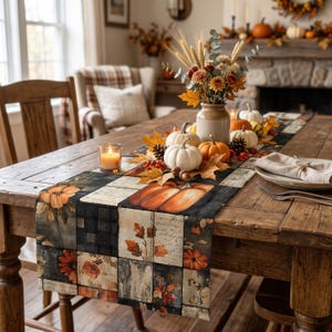 May include: A rectangular table runner featuring a patchwork design of black and white buffalo plaid, orange pumpkins, autumn leaves, and script text. The runner is displayed on a wooden table with a centerpiece of pumpkins and dried flowers.