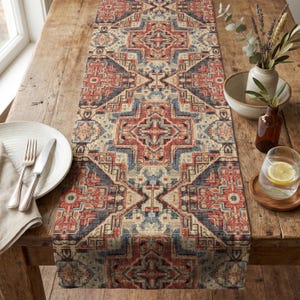 May include: A rectangular table runner featuring a repeating geometric pattern in shades of red, blue, and cream. The textile displays intricate, symmetrical cross-shaped motifs arranged in a continuous vertical design across the fabric surface.