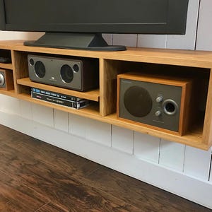 Solid white oak floating media console. Wall mounted tv and video cabinet.