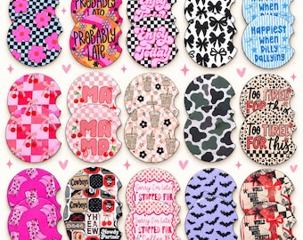 May include: A collection of thirty circular car coasters featuring various graphic designs including checkered patterns, floral motifs, bows, cow print, leopard print, and text such as Probably Late, Enjoy Today, Mama, and World Needs More Cowboys.