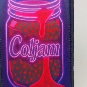 May include: A rectangular patch featuring a neon-style illustration of a glass jar filled with red jam. The word Coljam is written in a neon purple script across the centre of the jar, with red jam dripping down the front over the text.