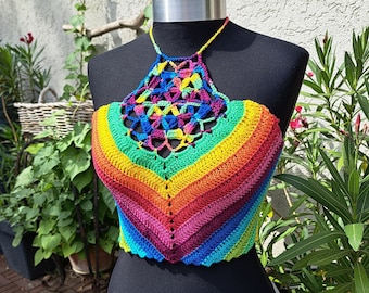 Puede incluir: Un top de crochet halter arcoíris con un patrón geométrico. El top está hecho con una variedad de colores, incluyendo rojo, naranja, amarillo, verde, azul, índigo y violeta.