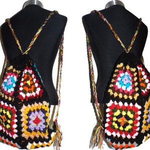 以下が含まれることがあります： 幾何学模様のカラフルな手編みのバックパック。バックパックは、赤、オレンジ、黄色、緑、青、紫など、さまざまな色の正方形でできています。バックパックには、さまざまな身長に合わせて調整できる長いストラップが付いています。