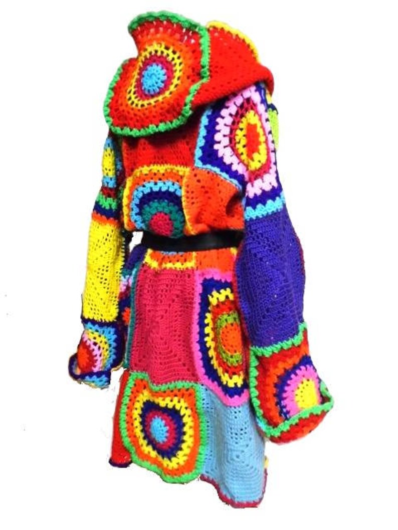 May include: A vibrant, patchwork crochet jacket in a variety of colors, including red, yellow, blue, and green. The jacket features a hood and a unique, geometric design. The sleeves are long and the jacket has a skirt-like bottom.