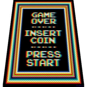 May include: Black rectangular blanket with pixelated text that reads "GAME OVER", "INSERT COIN", and "PRESS START". The text is in a retro arcade game style, with a colorful border of red, orange, yellow, green, blue, and white stripes.