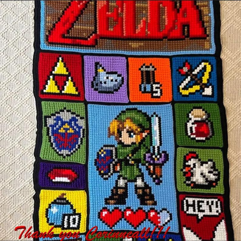 以下が含まれることがあります： ゼルダの伝説のビデオゲームキャラクター、リンクのピクセルデザインが施された、かぎ針編みの壁掛け。デザインには、リンクの剣、盾、ハートコンテナが含まれています。デザインの上部には「ゼルダ」という言葉があります。
