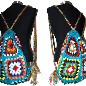 以下が含まれることがあります： 幾何学模様のカラフルな手編みのバックパック。バックパックは、赤、オレンジ、黄色、緑、青、茶色など、さまざまな色の正方形でできています。バックパックには、さまざまな身長に合わせて調整できる長いストラップが付いています。