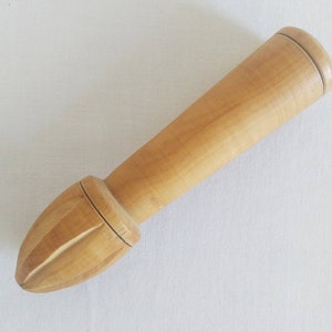 May include: A wooden citrus juicer with a long handle and a pointed end with ridges for squeezing fruit.