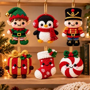 Pode incluir: Um conjunto de seis enfeites de Natal de crochê pendurados em duas fileiras. A fileira superior apresenta um elfo, um pinguim com protetores de ouvido e cachecol, e um quebra-nozes. A fileira inferior inclui um presente, uma meia e um doce.