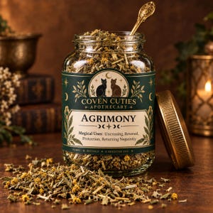 May include: A clear glass jar filled with dried agrimony herbs, featuring a dark green label with gold text reading Coven Cuties Apothecary, Agrimony, and Magical Uses: Uncrossing, Reversal, Protection, Returning Negativity. A gold lid sits beside the jar.