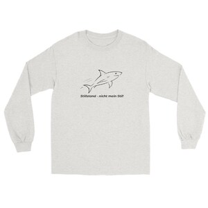 Könnte beinhalten: Ein hellgraues Langarmshirt mit einer schwarzen Strichzeichnung eines vorwärts schwimmenden Hais. Unter dem Hai steht der Text Stillstand - nicht mein Stil! Das Shirt hat einen Rundhalsausschnitt und lange Ärmel mit gerippten Bündchen.