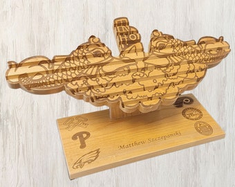 May include: A wooden plaque with a carved image of a submarine dolphin, a common symbol for the United States Navy's Submarine Force. The plaque is personalized with the name "Matthew Szczepanski" and the Philadelphia Eagles logo.