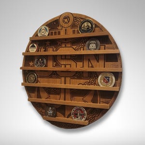 Puede incluir: Un expositor de monedas redondo de madera con un ancla y las letras USN grabadas en &eacute;l. El expositor tiene seis estantes para guardar monedas. Hay varias monedas en los estantes.