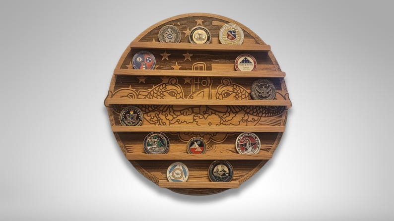 Puede incluir: Un expositor de monedas redondo de madera con una imagen tallada de dos delfines y una bandera estadounidense. El expositor tiene seis estantes para guardar monedas.