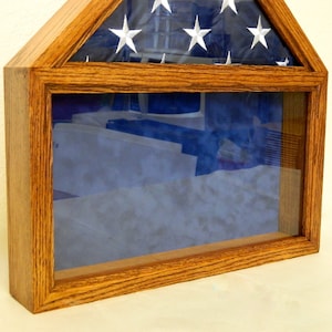 May include: A wooden flag display case with a glass front and a blue velvet lining. The case is designed to hold a folded American flag.