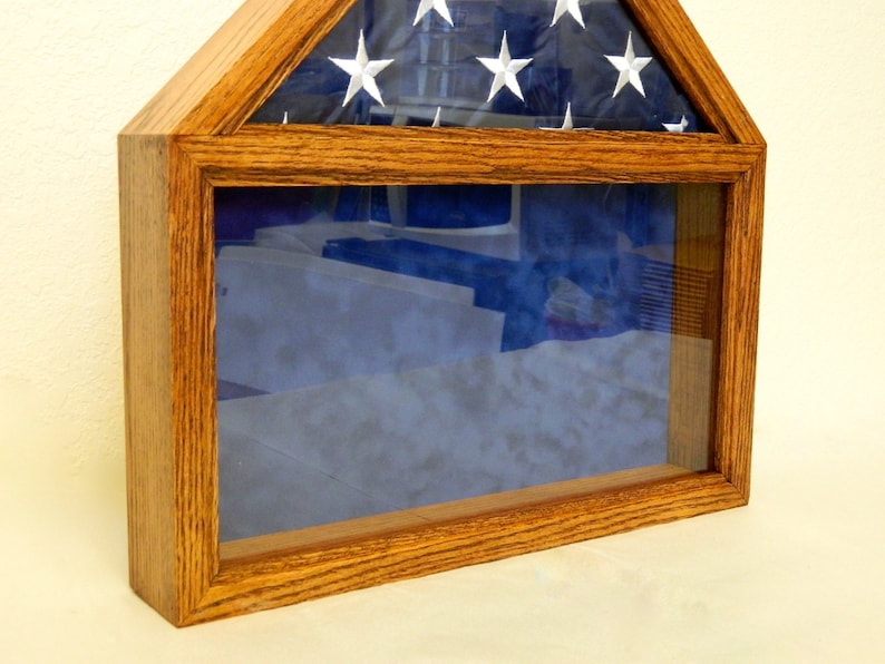 May include: A wooden flag display case with a glass front and a blue velvet lining. The case is designed to hold a folded American flag.