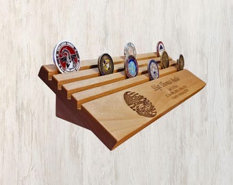 May include: Wooden display shelf with slots for holding challenge coins. The shelf is angled and has a personalized inscription that reads "Sgt Thomas Miller, USMC, Served with Honor, Semper Fidelis".