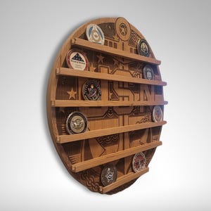 Puede incluir: Un expositor de monedas redondo de madera con un ancla de la Marina de los EE. UU. tallada y las letras USN. El expositor tiene 8 ranuras para monedas y est&aacute; decorado con estrellas y otros dise&ntilde;os n&aacute;uticos.