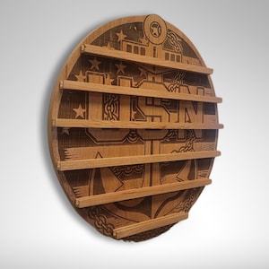 Puede incluir: Una placa redonda de madera con un logotipo USMC grabado y cinco ranuras para exhibir medallas. La placa est&aacute; hecha de madera marr&oacute;n claro y tiene un acabado desgastado.