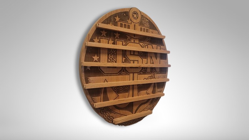 Puede incluir: Una placa redonda de madera con un logotipo USMC grabado y cinco ranuras para exhibir medallas. La placa est&aacute; hecha de madera marr&oacute;n claro y tiene un acabado desgastado.